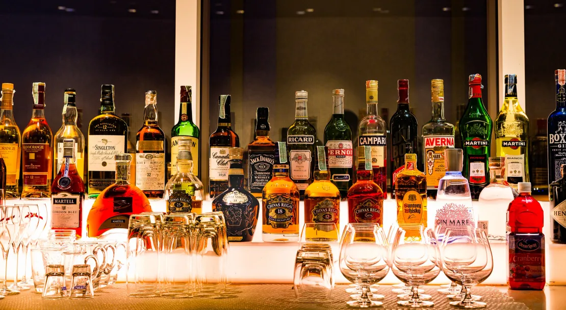Bar shelf with assorted liquor bottles displayed.